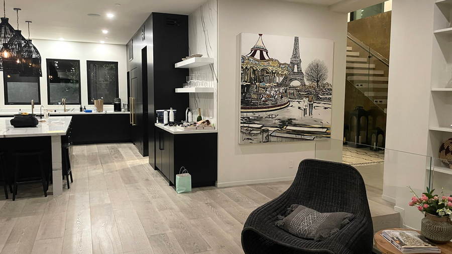 A large original painting in black and white of Paris and the Eiffel tower painted by California artist Brooke Harker hanging on a wall in a modern home.