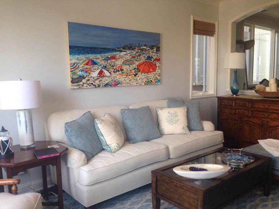 painting of Laguna Beach California by artist Brooke Harker hanging on a wall over a sofa in a coastal style home