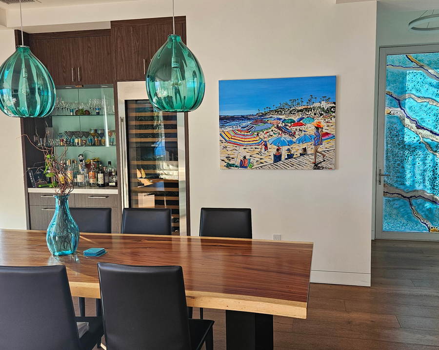 A Sold riginal oil painting of Laguna Beach California painted by artist Brooke Harker hanging on a wall in dining room of a California coastal home