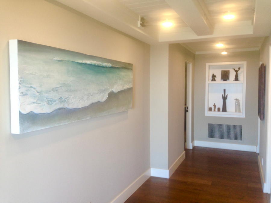 long horizontal contemporary coastal beach seascape painting by Laguna Beach artist Dasha Guilliam hanging on a hallway wall.