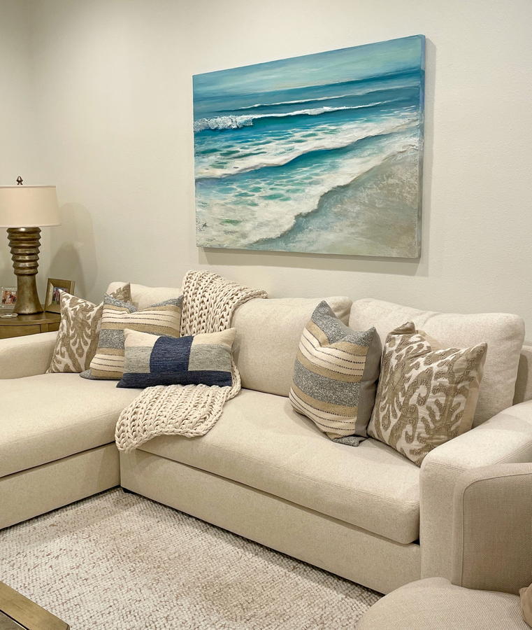 Original contemporary coastal mixed media artwork by Laguna Beach artist Dasha Guilliam hanging on wall over a sofa in a coastal style living room interior.