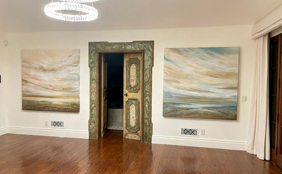 Two large custom commissioned mixed media contemporary coastal paintings by artist Dasha Guilliam hanging on large bedroom walls in a California home.